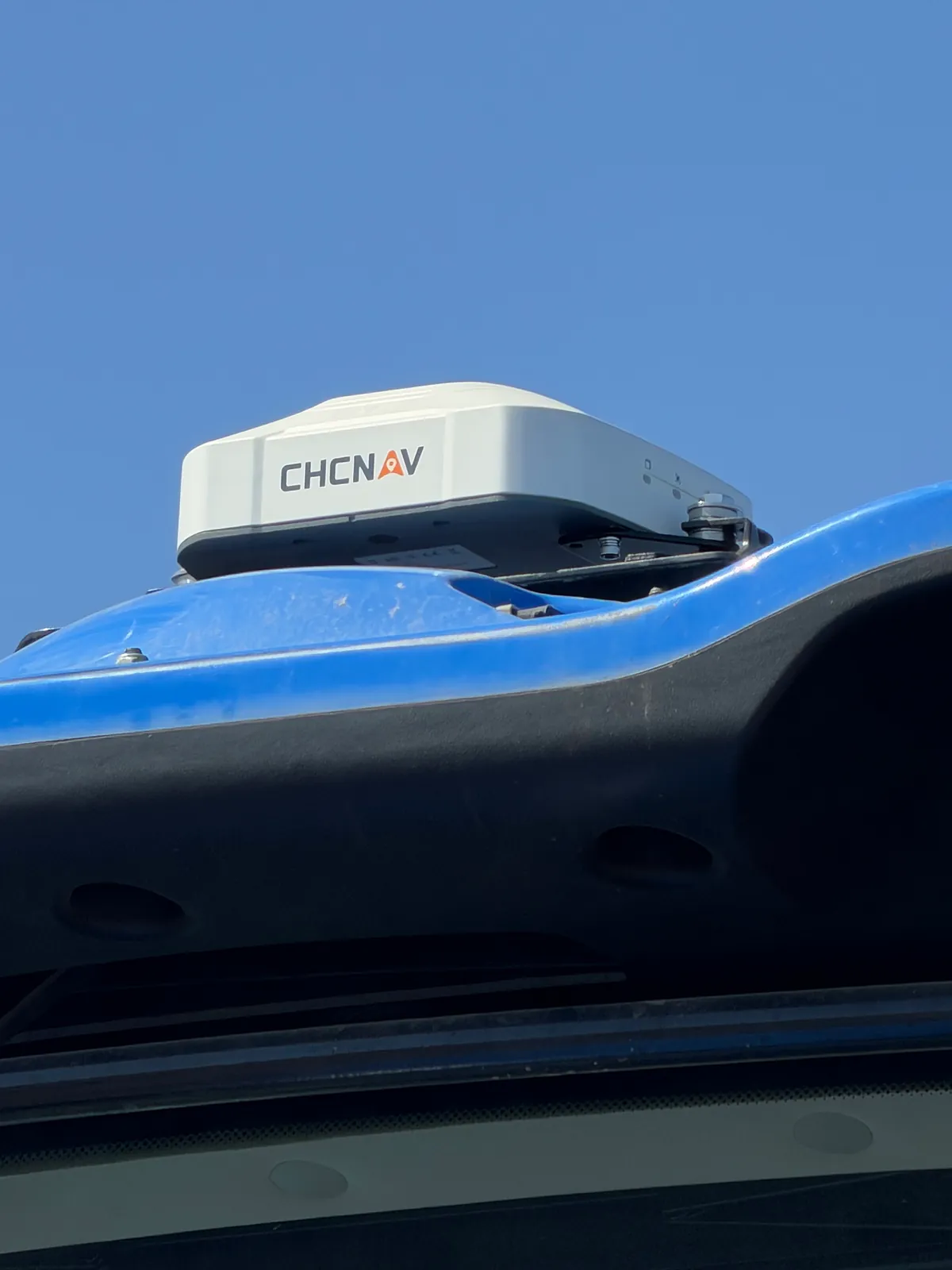 CHCNAV receiver on the cab roof of a New Holland T8 tractor