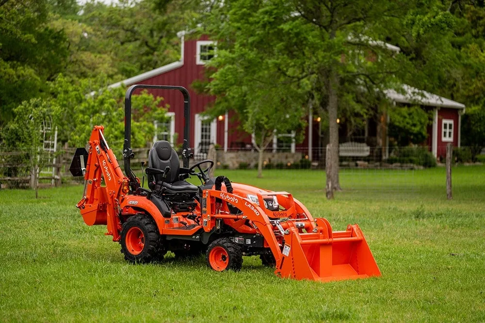 Kubota BX23S tractor-loader-backhoe with front loader and backhoe on a farm lawn