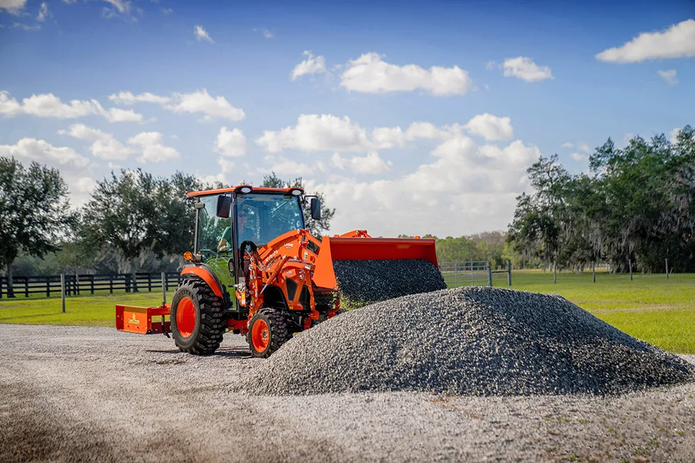 Kubota LX4020 cab compact tractor loading gravel with a front loader