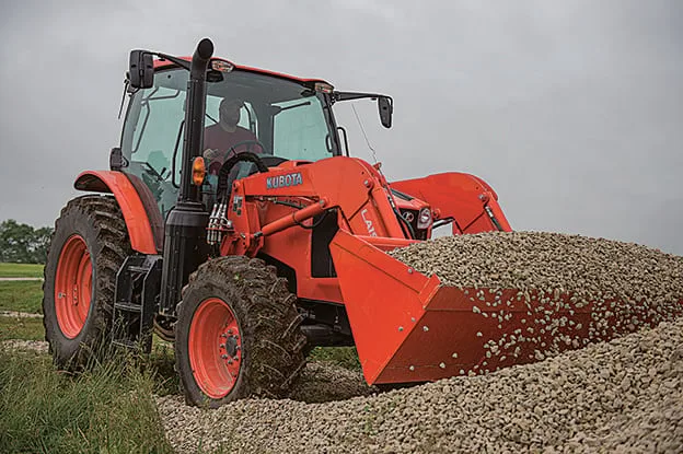 Kubota M6-101 production utility tractor loading gravel with a front loader