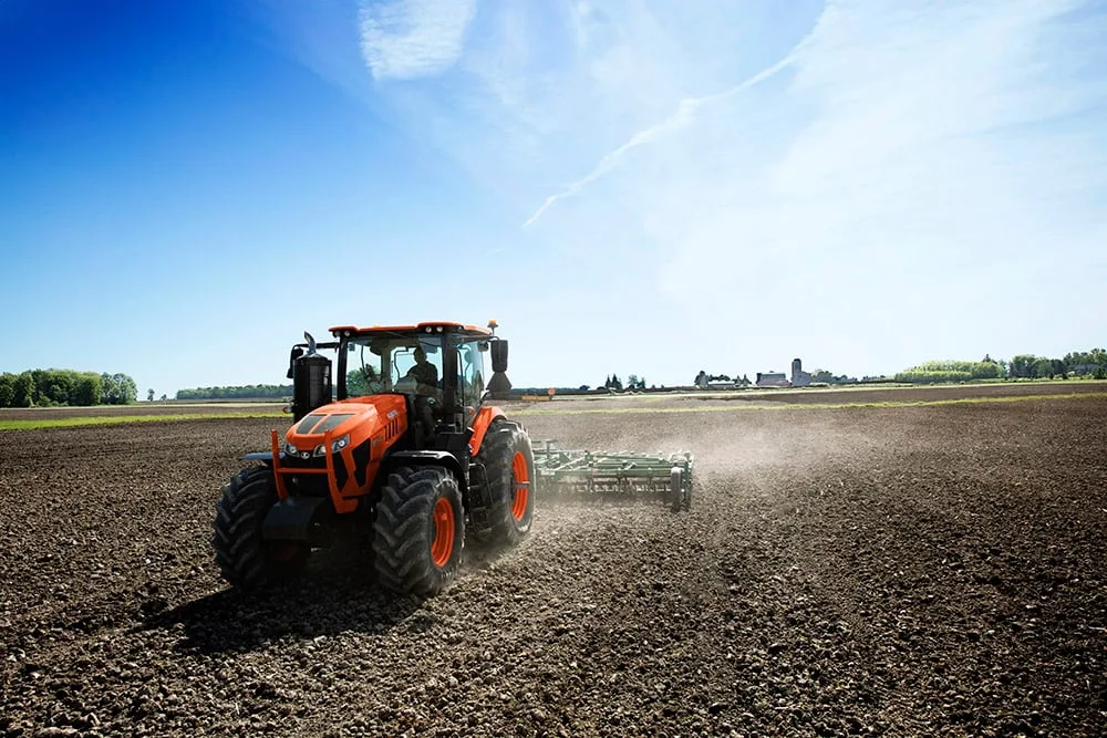 Kubota M8-201 tractor pulling a cultivator across a tilled field
