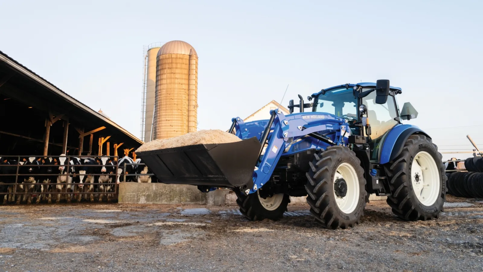 Representative New Holland PowerStar tractor with a front loader at a dairy