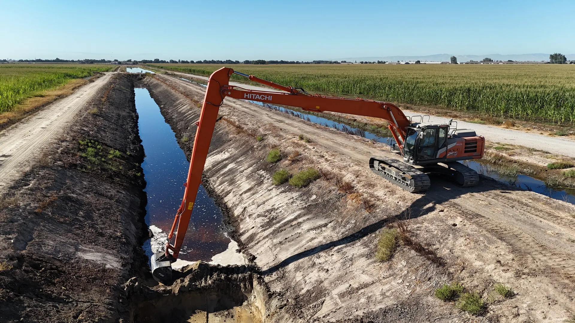 Long-reach Hitachi excavator working along a canal