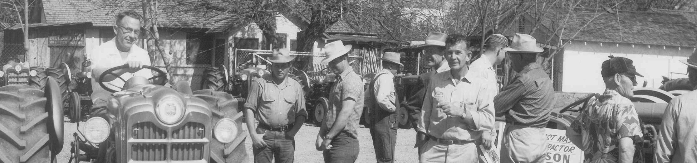 Garton Tractor staff with vintage Ford tractor at an outdoor sales event in the 1960s