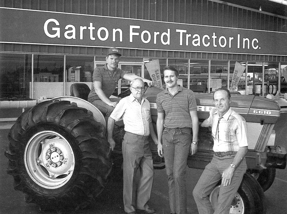 Four generations of the Garton family in front of a Ford 6610 tractor outside the Garton Ford Tractor Inc. store